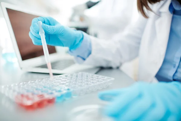 Trabajador médico con fluidos de prueba de gotero — Foto de Stock