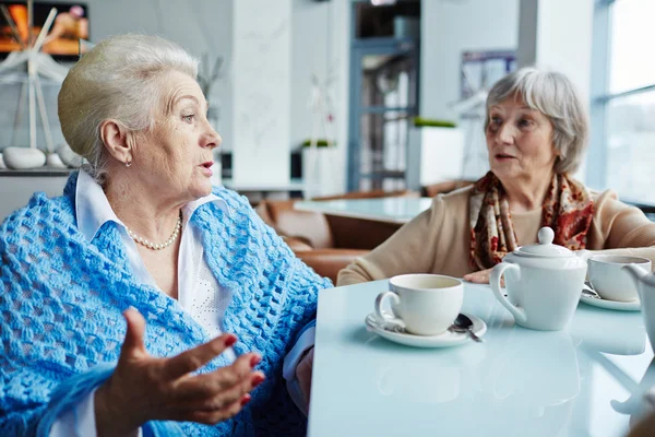 Старші друзі розмовляють у кафе — стокове фото