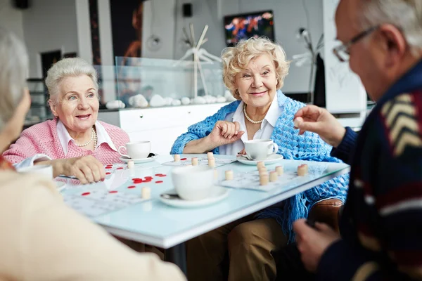 Pessoas amigáveis jogando loteria no café — Fotografia de Stock