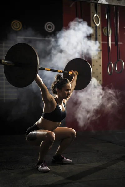 Mulher levantando barbell — Fotografia de Stock