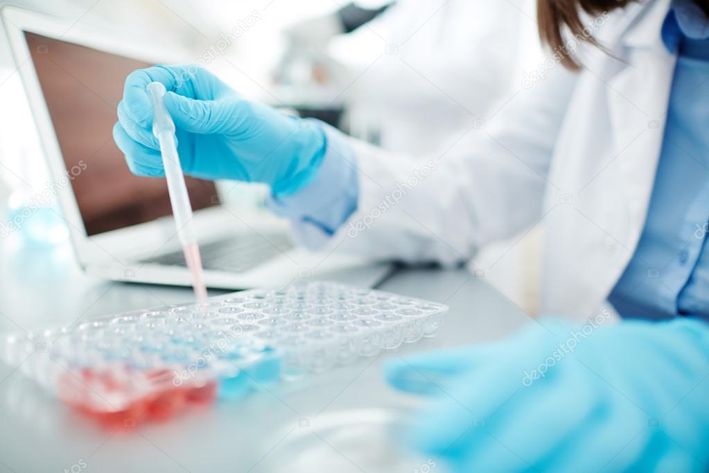 Medical worker with dropper testing fluids 