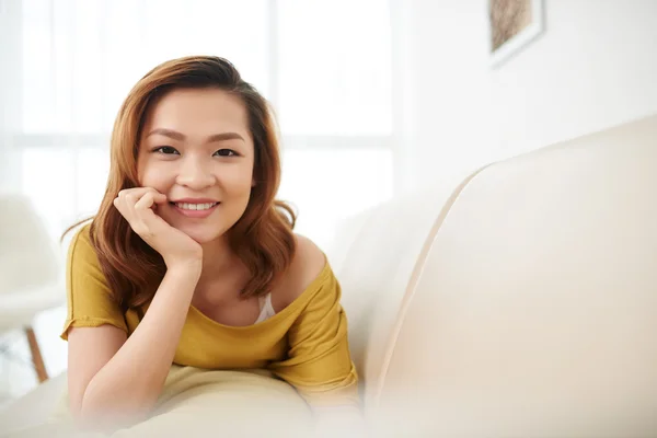 Asiática chica acostada en sofá — Foto de Stock