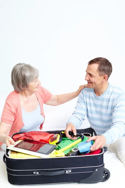 Glückliches Senioren-Paar packt Koffer — Stockfoto