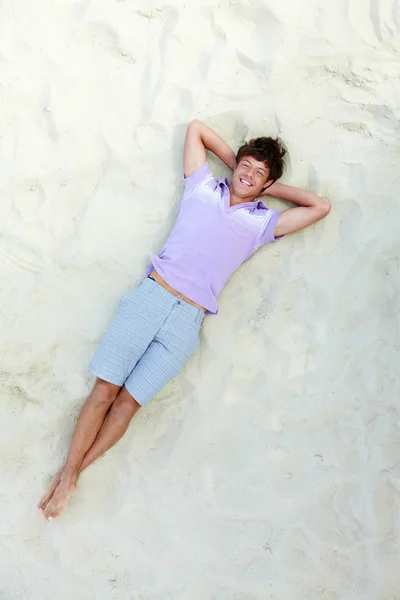 Adolescent beau couché sur la plage de sable fin — Photo