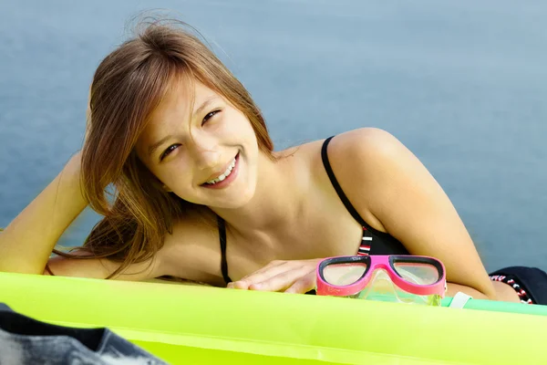 Schönes Mädchen im Bikini auf Matratze liegend — Stockfoto