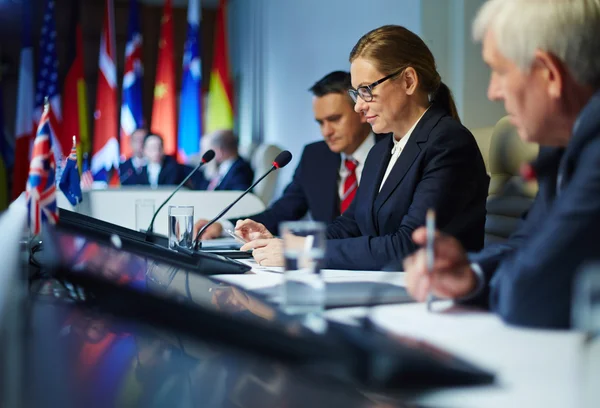 Businesswoman using her smartphone during the conference — Stock Photo, Image