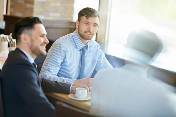 Les hommes d'affaires parlent autour d'une tasse de café — Photo