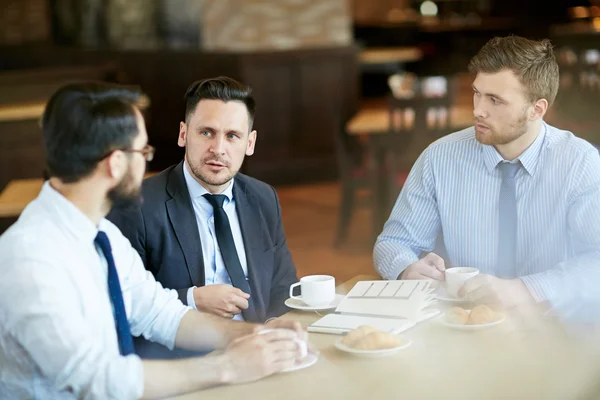 Hommes d'affaires prenant un café et partageant des idées . — Photo