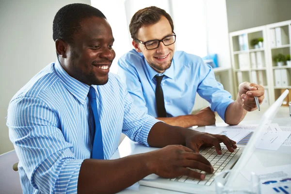 Empresários sorridentes usando Laptop no escritório — Fotografia de Stock