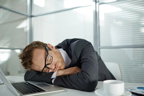 Müder Geschäftsmann schläft an seinem Arbeitsplatz — Stockfoto