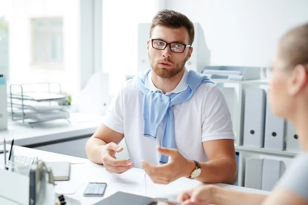 Homem de óculos conversando com sua colega — Fotografia de Stock