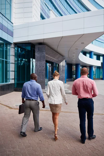 Des gens d'affaires multiethniques se rendent à pied à l'immeuble de bureaux — Photo