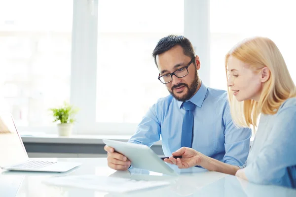 Businessman and businesswoman using touchpad together — Stock Photo, Image