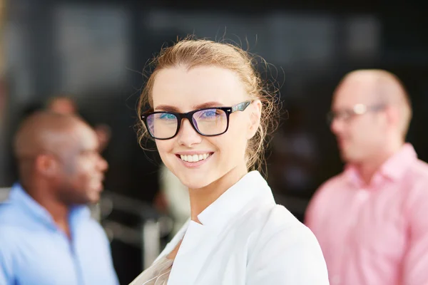 Mujer de negocios con anteojos sonriendo a la cámara —  Fotos de Stock