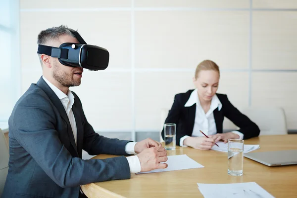 Empregador em fones de ouvido vr sentado por mesa — Fotografia de Stock