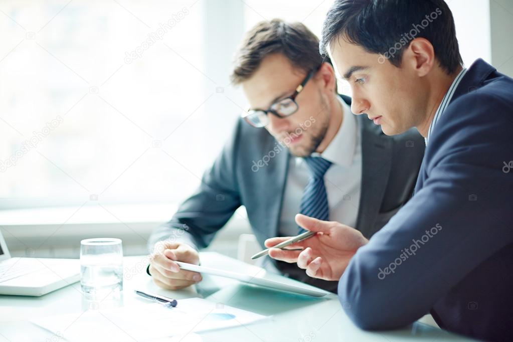 Businessmen using digital tablet on meeting