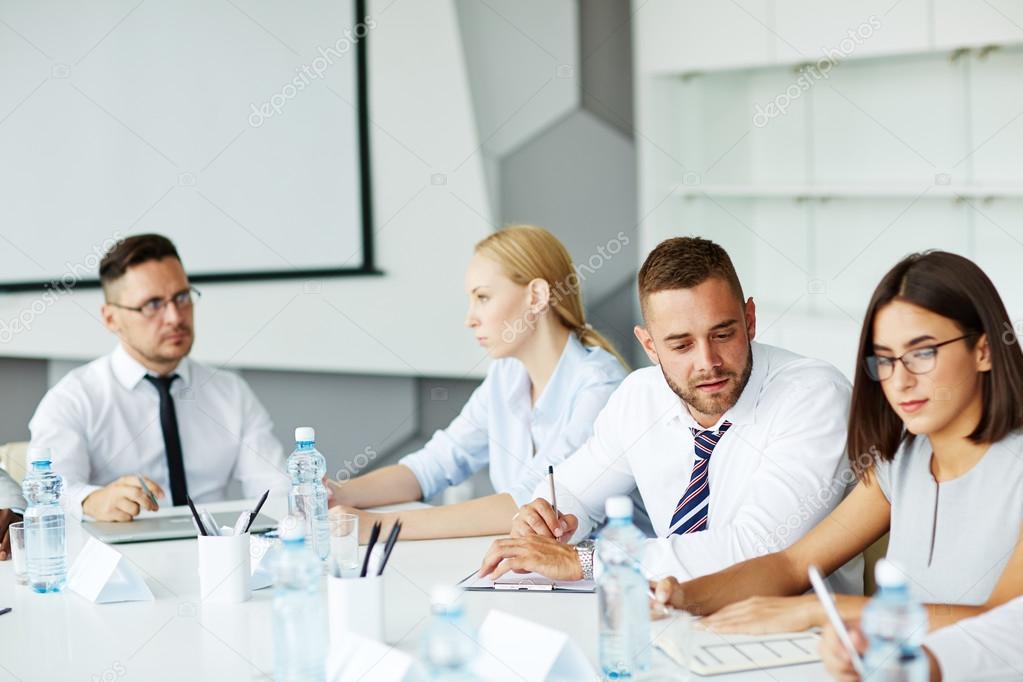 Managers making notes at conference