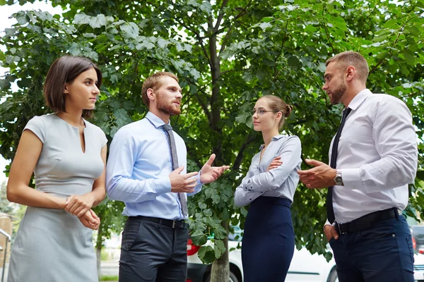 Groupe de collègues parlant dans le parc — Photo