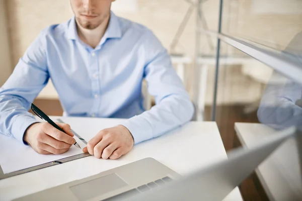 Seriöser Geschäftsmann macht Notizen in Dokument — Stockfoto