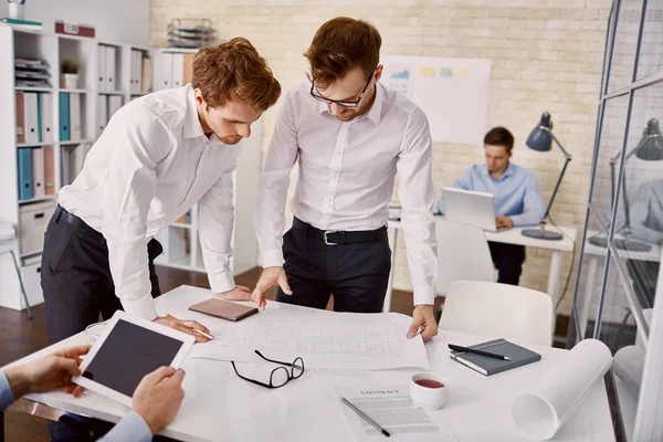 Les jeunes architectes examinent le plan directeur au bureau — Photo