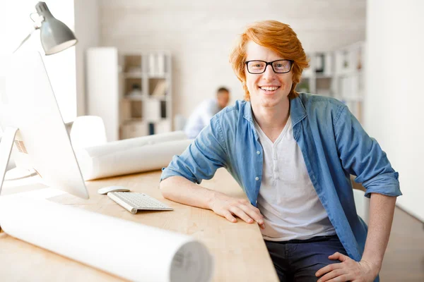 Jovem designer feliz sentado no local de trabalho — Fotografia de Stock