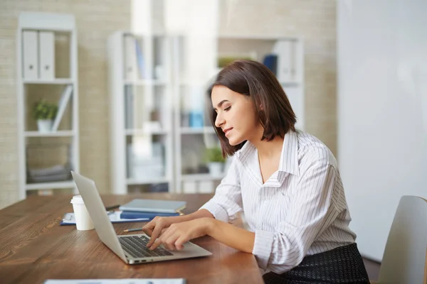 Jovem empresária digitando no laptop — Fotografia de Stock