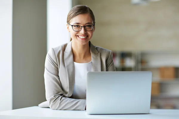 Erfolgreiche Geschäftsfrau sitzt an ihrem Arbeitsplatz — Stockfoto