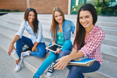 açık havada oturup üç öğrenci