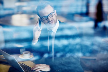 Kendine güvenen iş adamı telefonda konuşuyor.