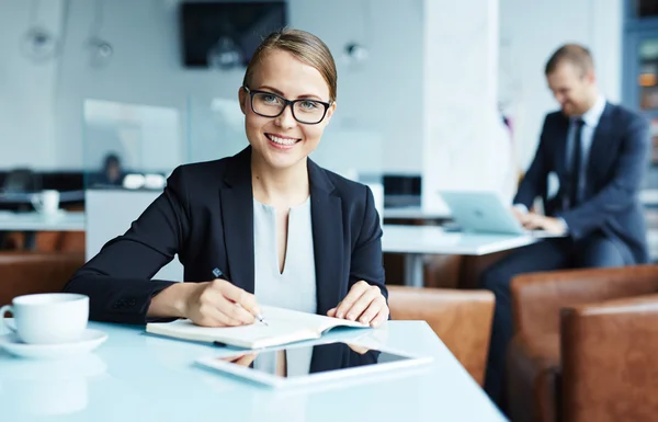 Lachende secretaris werken op haar werkplek — Stockfoto