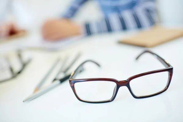 Óculos na mesa do escritório — Fotografia de Stock