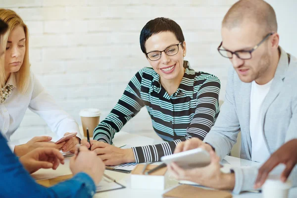 Compañeros de trabajo que utilizan aparatos modernos en la reunión — Foto de Stock