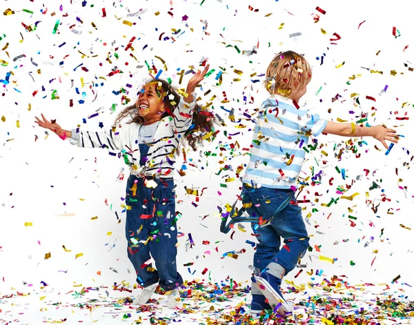 Happy children playing with confetti — Stock Photo, Image