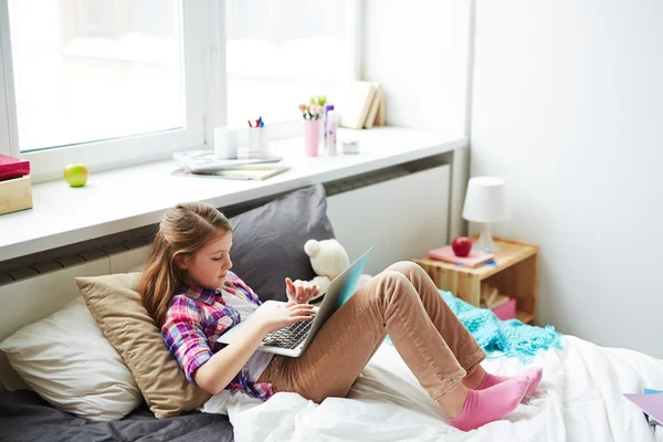 Έφηβο κορίτσι που χρησιμοποιούν φορητό υπολογιστή στο κρεβάτι — Φωτογραφία Αρχείου
