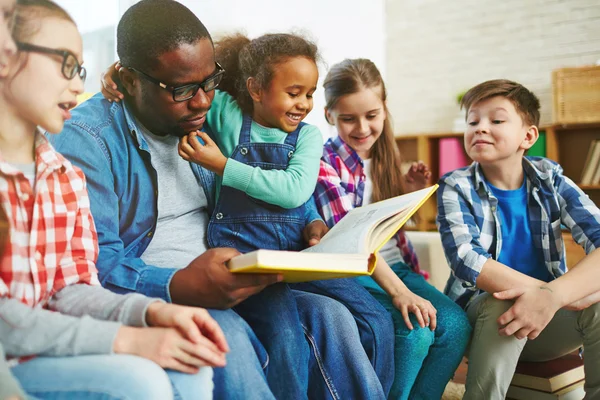 Petits élèves et enseignants lisant le livre — Photo