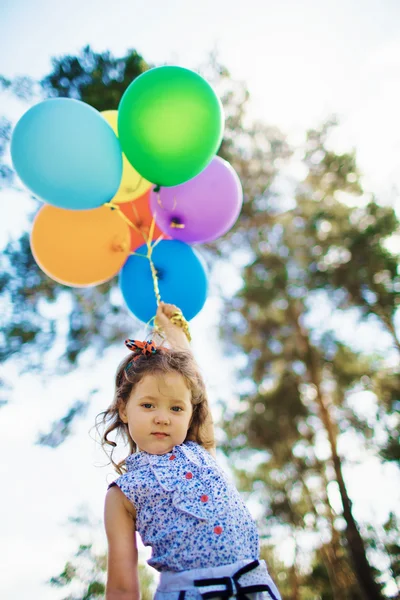 Menina bonito com balões coloridos — Fotografia de Stock