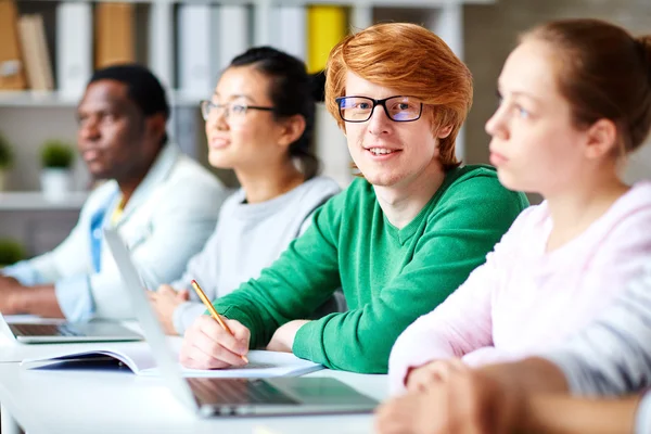 Ritratto di studente universitario seduto alla scrivania — Foto Stock