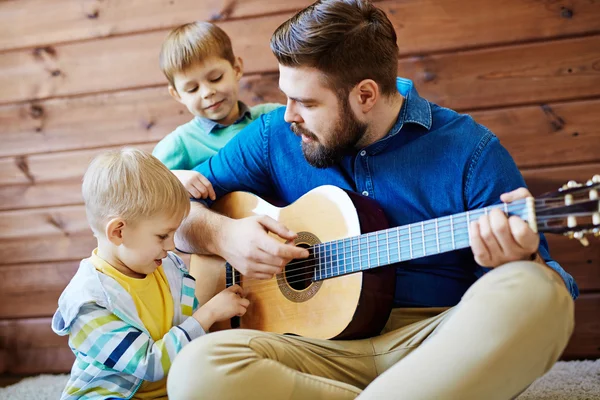 Szakállas férfi adj hámhúszt gitár — Stock Fotó