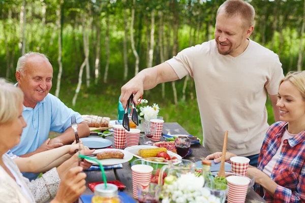 Man giving sausage to woman — Stock Photo, Image