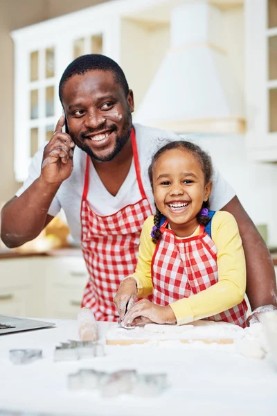 Mädchen kocht, während ihr Vater — Stockfoto