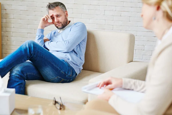 Stressed man sitting on sofa — Stock Photo, Image