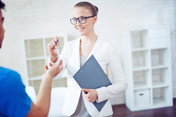 Empresária dando uma chave para o homem — Fotografia de Stock