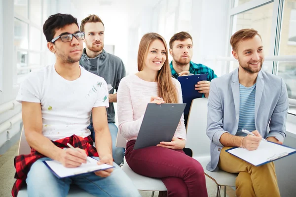 Young people sitting on chairs — Stock Photo, Image