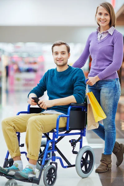 Jovem em Cadeira de Rodas Compras com Mulher — Fotografia de Stock