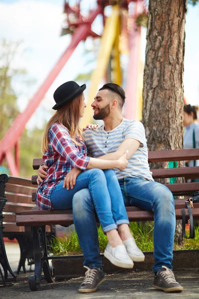 Pareja joven sentada en el banco — Foto de Stock