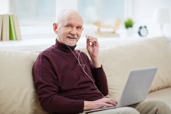 Leende senior mannen i hörlurar — Stockfoto