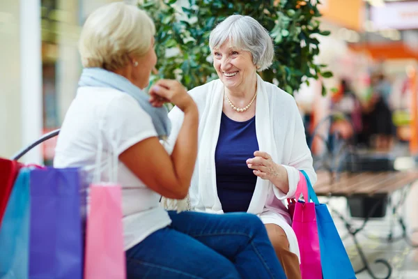 Friendly pensioners with shopping bags — Stock Photo, Image