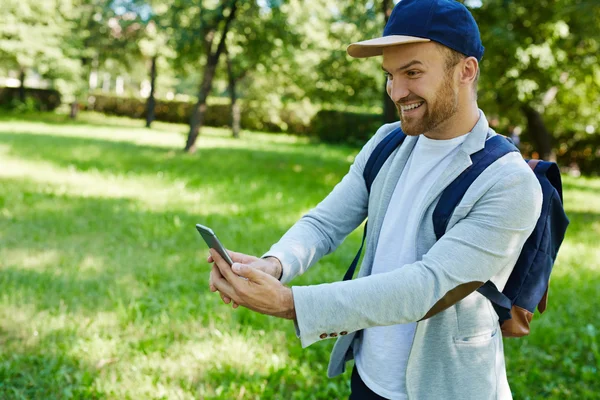 Hombre sonriente con teléfono celular — Foto de Stock