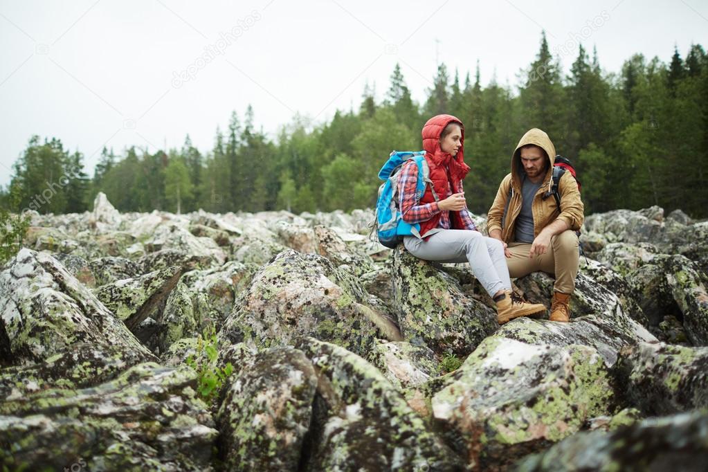 Travelers siting on big stones