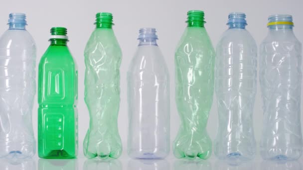粉碎站在孤立的白色背景上的一排排空的塑料水瓶 — 图库视频影像